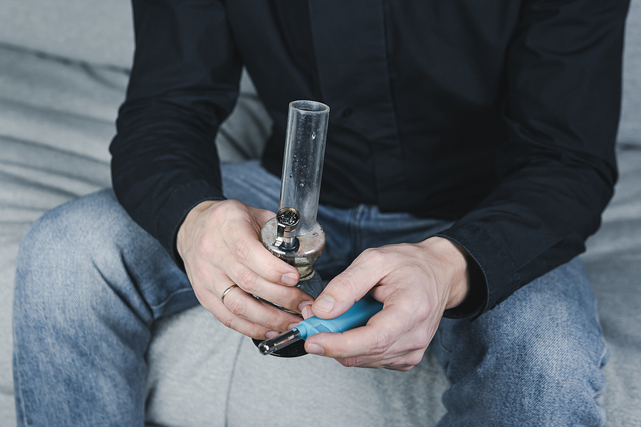 Young man smoking in glass water pipes